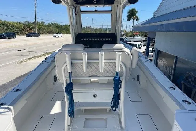 Slide: The Image of 2024 World Cat 260 CC-X boat interior with rod holders and seating, parked near a road. - 3