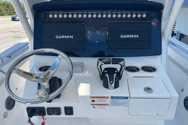Slide: The Image of 2024 World Cat 260 CC-X boat dashboard with Garmin navigation system and steering wheel. - 4