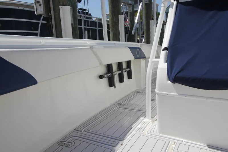 Slide: The Image of 2007 Fountain 34 Sportfish CC boat docked, showcasing its overhead structure and rod holders. - 21