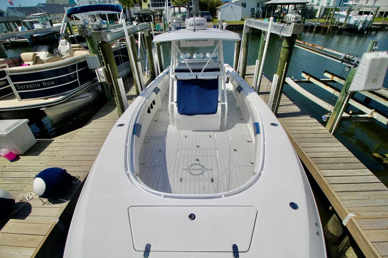 Slide: The Image of 2007 Fountain 34 Sportfish CC boat docked at marina, showcasing spacious deck and sleek design. - 3