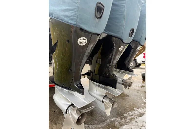 Slide: The Image of 2007 Fountain 34 Sportfish CC with triple outboard engines docked by waterfront homes. - 32