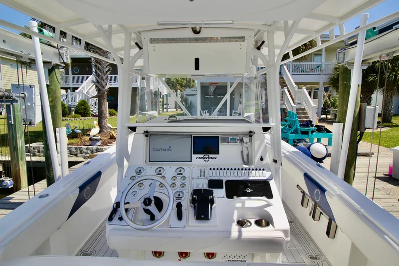 Slide: The Image of 2007 Fountain 34 Sportfish CC boat cockpit with Garmin navigation, docked near waterfront homes. - 7