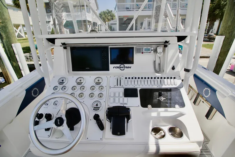 Slide: The Image of 2007 Fountain 34 Sportfish CC boat dashboard with steering wheel and control panel. - 8