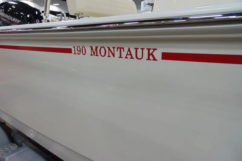 Slide: The Image of 2026 Boston Whaler 190 Montauk boat side view with red lettering. - 1