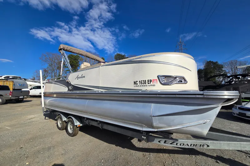 The Image of 2020 Avalon LSZ VRB 24' pontoon boat on trailer under clear blue sky. - 0