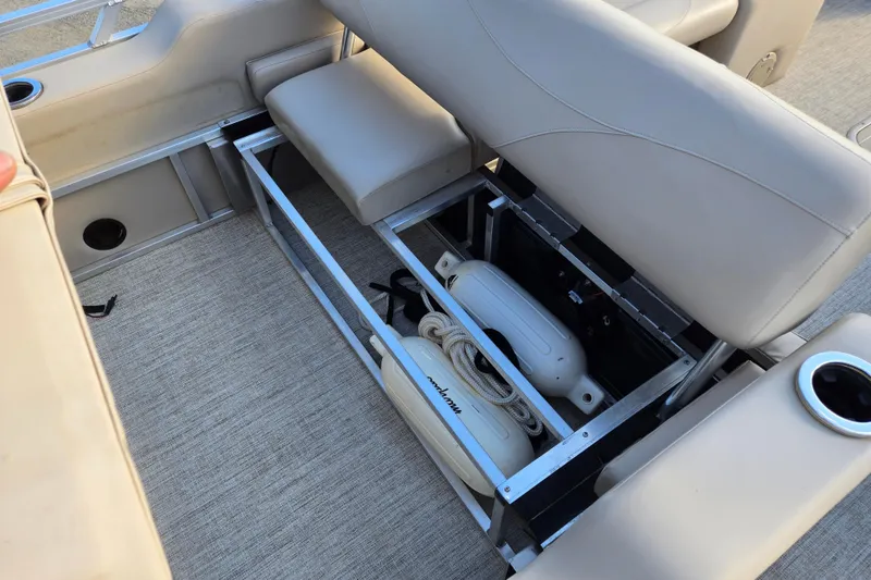 Slide: The Image of 2020 Avalon LSZ VRB 24' boat interior storage with beige seating and cup holder. - 39