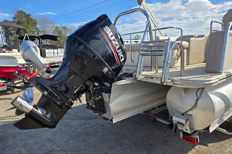 Slide: The Image of 2020 Avalon LSZ VRB 24' pontoon boat with Suzuki outboard motor, parked outdoors. - 7