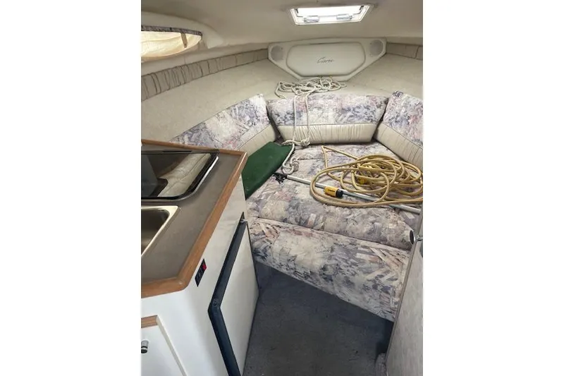 Slide: The Image of Interior of 1997 Bayliner 2355 boat with kitchenette and seating area. - 5