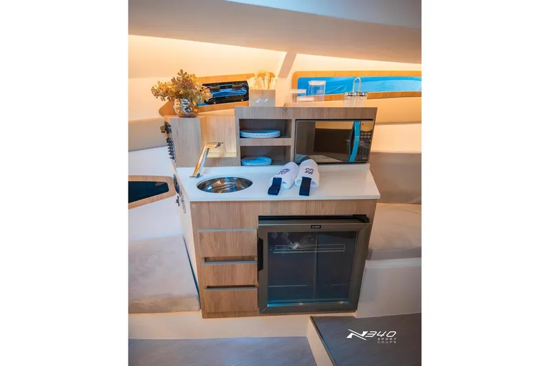 Slide: The Image of Luxurious interior of 2026 NX Boats NX340 featuring a modern kitchenette with amenities. - 13
