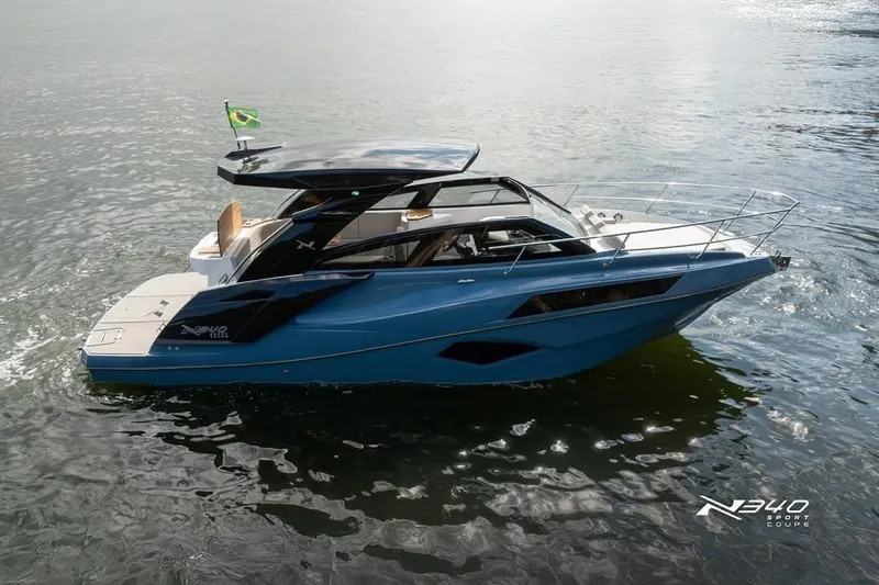 Slide: The Image of 2026 NX Boats NX340 cruising on water with Brazilian flag. - 3