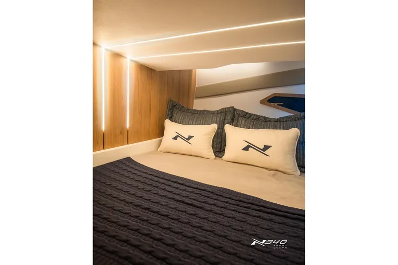Slide: The Image of Luxurious interior of 2026 NX Boats NX340 with cozy bedding and ambient lighting. - 6