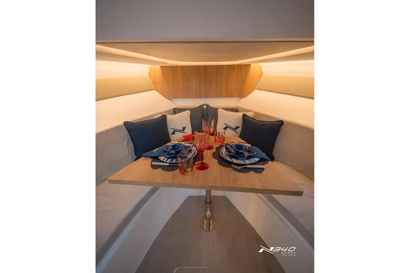 Slide: The Image of Luxurious interior of 2026 NX Boats NX340, featuring elegant dining setup with cushions. - 8