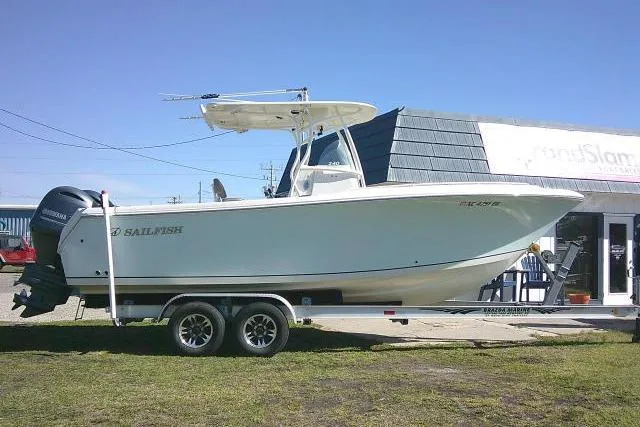 The Image of 2017 Sailfish 240 CC boat on trailer, parked outdoors near a building. - 0