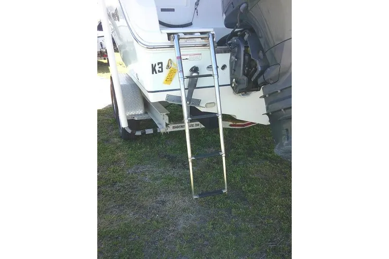 Slide: The Image of 2017 Sailfish 240 CC boat with ladder and motor on grassy area. - 10