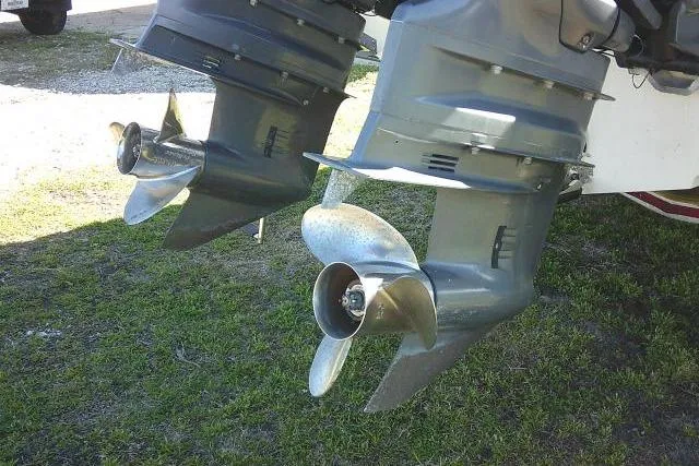 Slide: The Image of Twin outboard motors on a 2017 Sailfish 240 CC boat, resting on grass. - 11