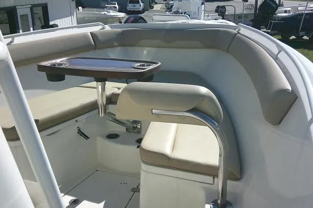 Slide: The Image of 2017 Sailfish 240 CC boat interior with cushioned seating and a small table. - 16