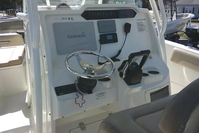 Slide: The Image of 2017 Sailfish 240 CC boat dashboard with Garmin navigation system and steering wheel. - 24