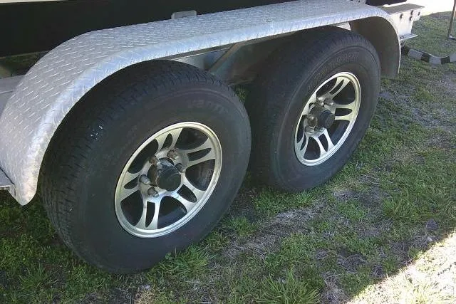 Slide: The Image of Trailer wheels for 2017 Sailfish 240 CC boat on grass. - 9