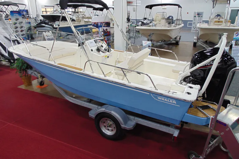 Slide: The Image of 2026 Boston Whaler 170 Montauk boat displayed indoors on a trailer. - 6