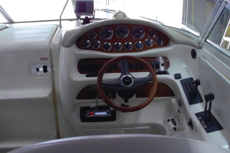 Slide: The Image of 1997 Sea Ray 280 Cuddy Cabin helm with wood accents and modern controls. - 3