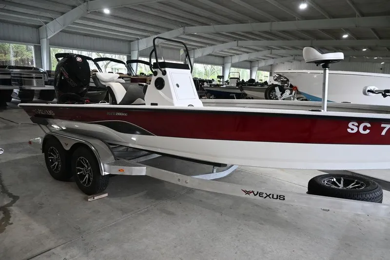 Slide: The Image of 2023 Vexus AVX2180CC boat in showroom, red and white design, on trailer. - 9