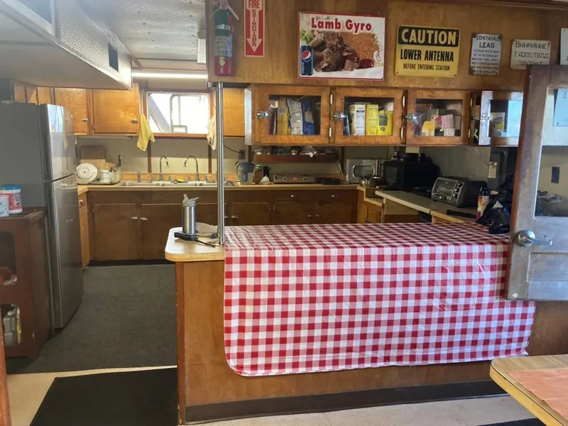 Slide: The Image of Kitchen interior of a 1981 custom lift boat with checkered tablecloth and vintage decor. - 13