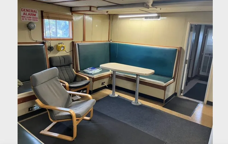 Slide: The Image of Interior of a 1981 custom lift boat with seating area and table. - 15