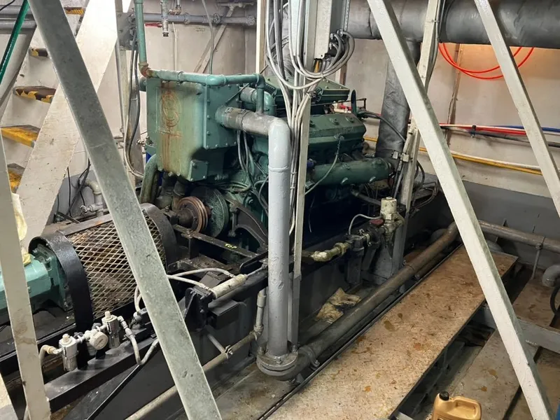 Slide: The Image of Engine room of a 1981 custom lift boat, featuring machinery and piping. - 21