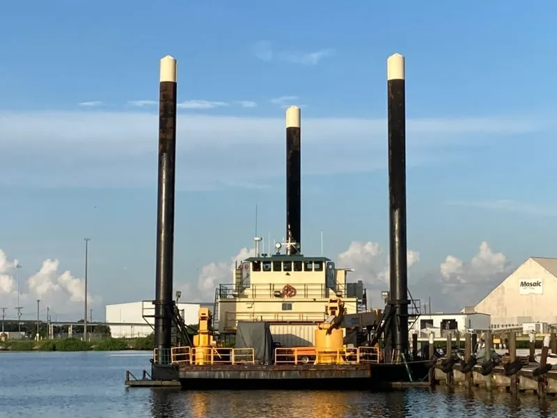 Slide: The Image of Custom 1981 lift boat docked with elevated legs against a clear blue sky. - 4