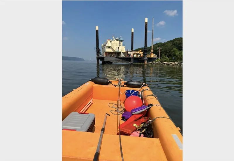 Slide: The Image of Orange boat approaching a 1981 Custom Lift Boat on calm water. - 8