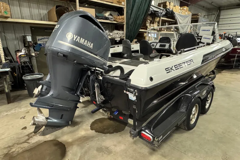 Slide: The Image of 2012 Skeeter WX2100 boat with Yamaha outboard motor in a garage setting. - 3