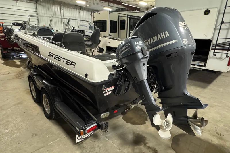 Slide: The Image of 2012 Skeeter WX2100 boat with Yamaha outboard motors in a garage setting. - 4