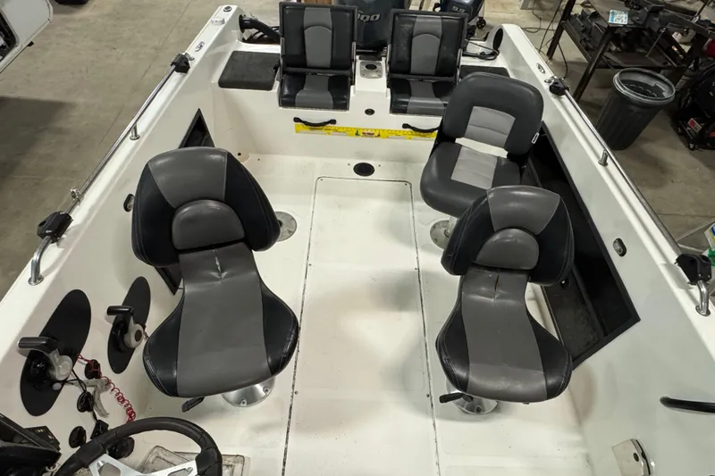 Slide: The Image of Interior of a 2012 Skeeter WX2100 boat with four black and gray seats. - 6