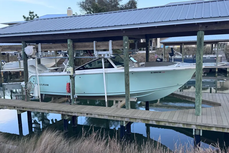 The Image of 2023 Sailfish 276 DC boat docked under a covered marina. - 1