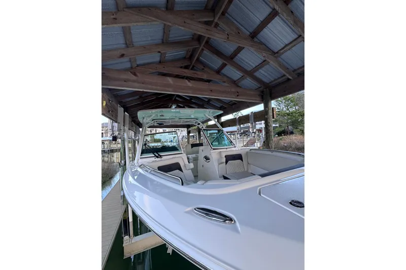 Slide: The Image of 2023 Sailfish 276 DC boat docked under wooden shelter. - 11