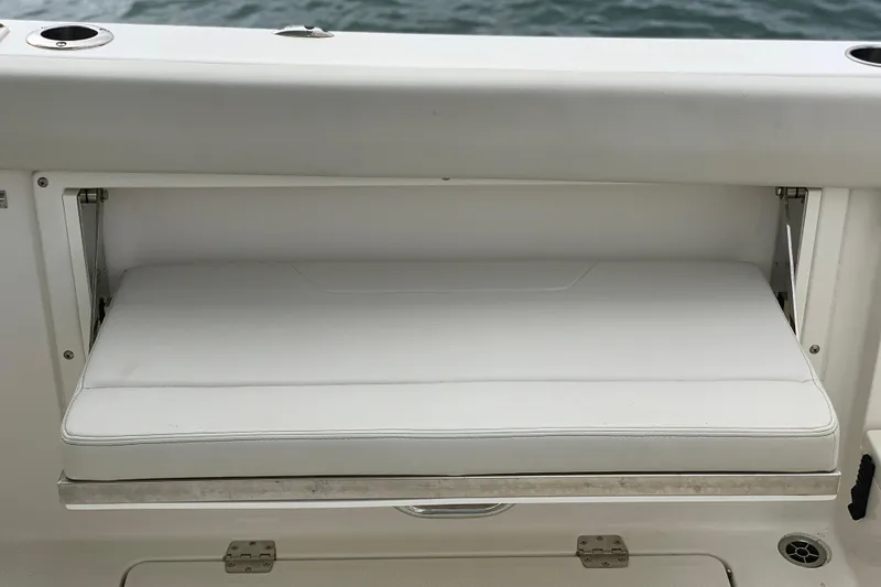 Slide: The Image of 2023 Sailfish 276 DC boat seat with white cushion, near water. - 22