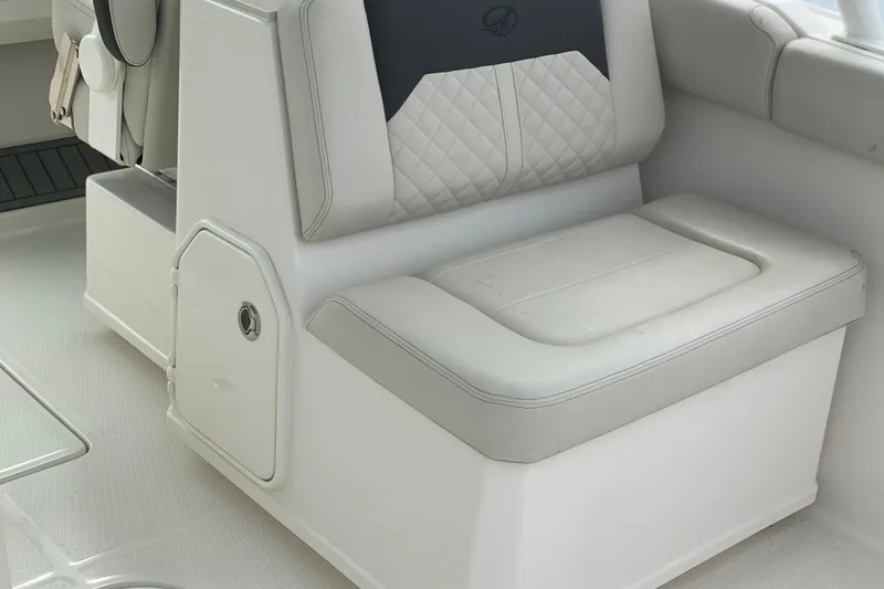 Slide: The Image of 2023 Sailfish 276 DC boat interior with cushioned seating and storage compartment. - 23