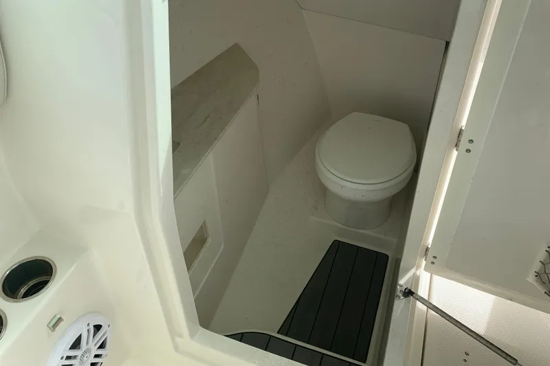 Slide: The Image of 2023 Sailfish 276 DC boat interior with compact marine toilet and storage area. - 28