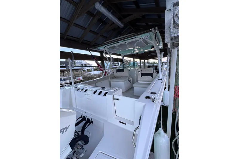 Slide: The Image of 2023 Sailfish 276 DC boat interior under a covered dock, showcasing seating and controls. - 5