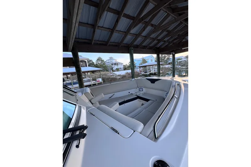 Slide: The Image of 2023 Sailfish 276 DC boat interior with spacious seating under a covered dock. - 8