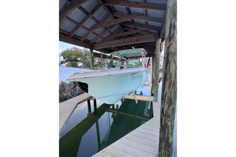 Slide: The Image of 2023 Sailfish 276 DC boat docked under a wooden shelter. - 9