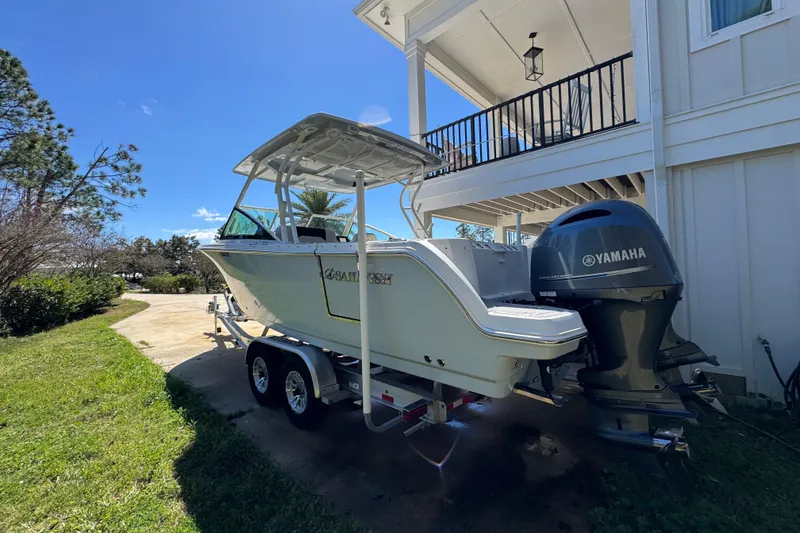 Slide: The Image of 2022 Sailfish 276 DC boat with Yamaha engine parked near a house. - 15