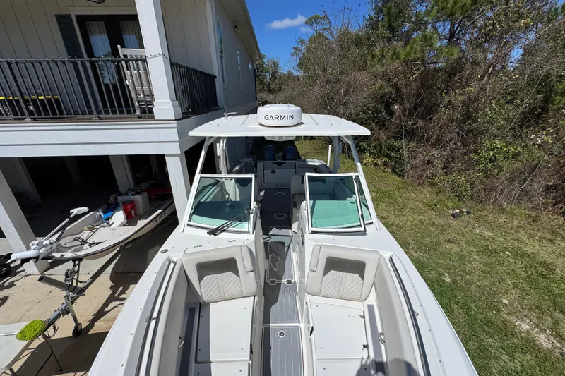 Slide: The Image of 2022 Sailfish 276 DC boat with Garmin equipment, parked near a house and trees. - 18