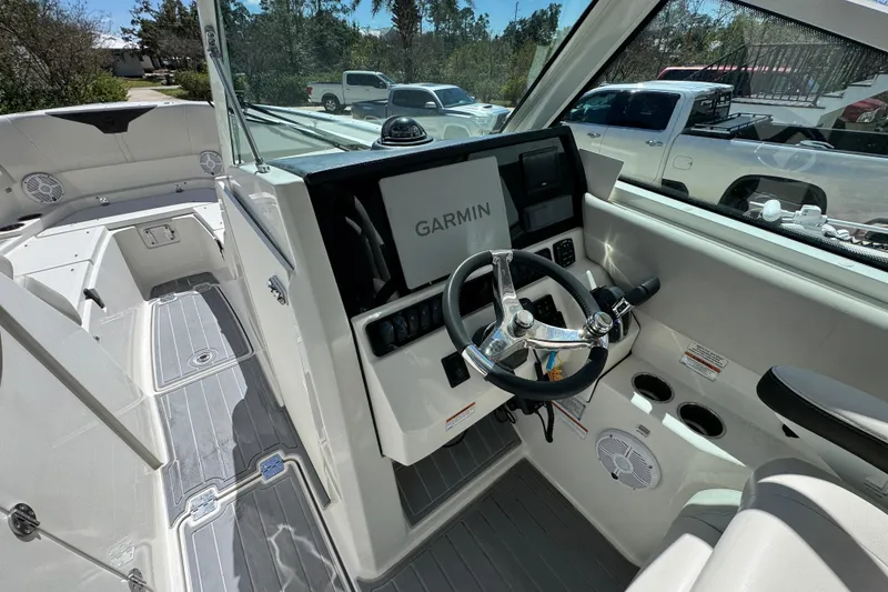 Slide: The Image of 2022 Sailfish 276 DC boat interior with Garmin navigation system and steering wheel. - 22