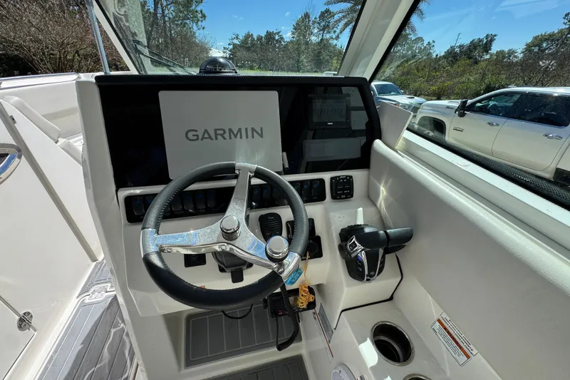 Slide: The Image of 2022 Sailfish 276 DC boat helm with Garmin navigation system and steering wheel. - 23