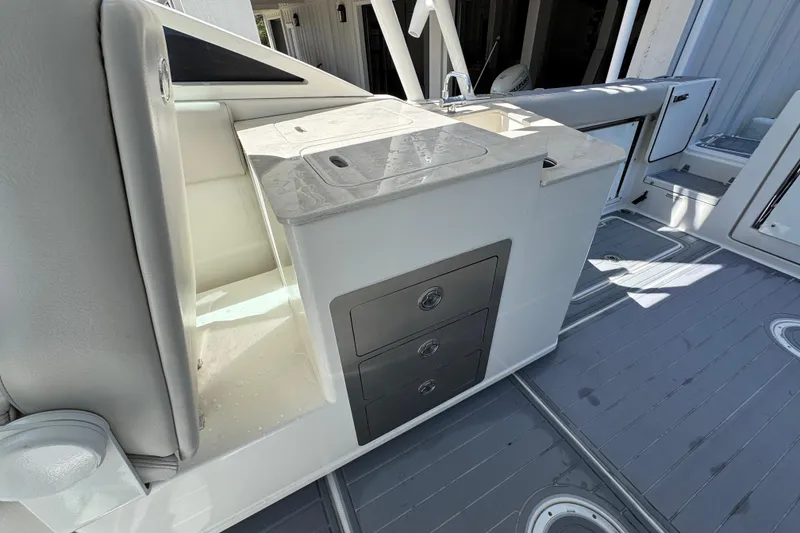 Slide: The Image of 2022 Sailfish 276 DC boat interior with storage drawers and countertop. - 26