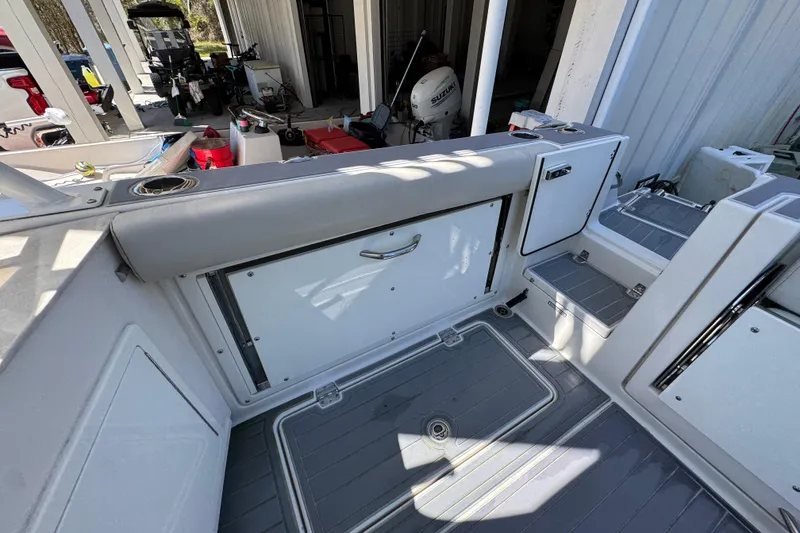 Slide: The Image of 2022 Sailfish 276 DC boat interior with storage compartments and seating area. - 33