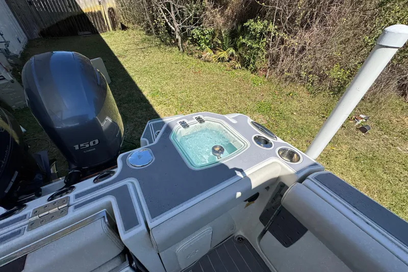 Slide: The Image of 2022 Sailfish 276 DC boat with Yamaha 150 engine and livewell, parked on grass. - 35