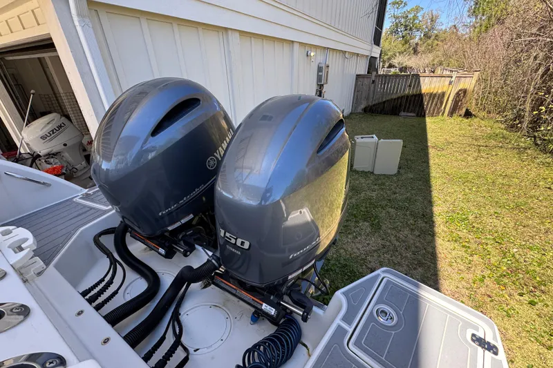 Slide: The Image of Twin Yamaha outboard engines on a 2022 Sailfish 276 DC boat, parked in a backyard. - 37