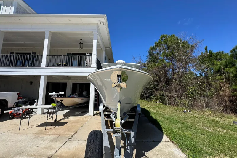 Slide: The Image of 2022 Sailfish 276 DC boat on trailer in driveway, sunny day, house and trees in background. - 6